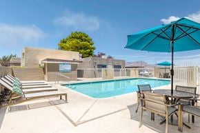 Kingman apartment for rent - View of pool from sundeck with lounge chairs and picnic table in the foreground.