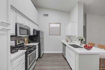 Las Vegas apartment for rent - A kitchen with white cabinets and a black stove top oven.
