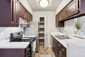 Mesa apartment for rent - A kitchen with brown cabinets and a white counter.