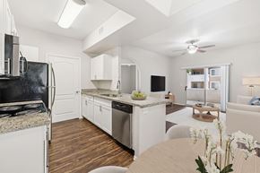 Tucson apartment for rent - A modern kitchen with white cabinets and a wooden floor.