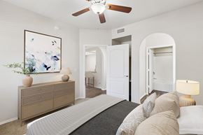 Tucson apartment for rent - A bedroom with a large bed and a painting on the wall.