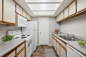 Mesa apartment for rent - A kitchen with white appliances and wooden cabinets.