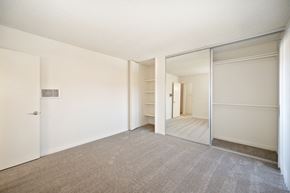 Carlsbad apartment for rent - an empty bedroom with mirrored closet doors and a carpeted floor