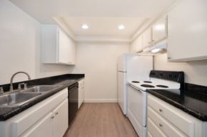 Carlsbad apartment for rent - a kitchen with white appliances and black counter tops and white cabinets