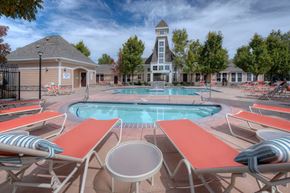 Reno apartment for rent - A pool surrounded by sun loungers and a building in the background.