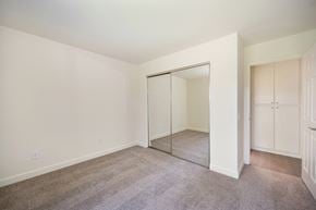 Carlsbad apartment for rent - a bedroom with carpet and a closet with a mirrored door