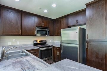 Laguna Niguel apartment for rent - A kitchen with brown cabinets and stainless steel appliances.