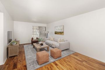 Kingman apartment for rent - A living room with a grey sofa, wooden coffee table, and a painting on the wall.
