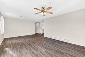 San Diego apartment for rent - Apartment living room with wood-style plank flooring, ceiling fan, and view to kitchen.