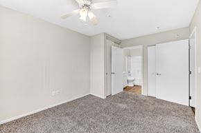 San Diego apartment for rent - Apartment bedroom with carpet, ceiling fan, and view to en suite bathroom.