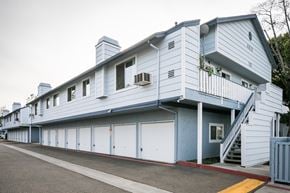 El Cajon apartment for rent - Blue and white building exterior with ground-floor garages.