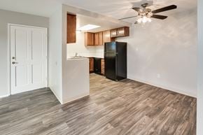El Cajon apartment for rent - Apartment dining room with ceiling fan, wood-style vinyl plank flooring, and view to kitchen.