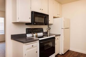 La Mesa apartment for rent - Apartment kitchen oven view with black microwave and white refrigerator.