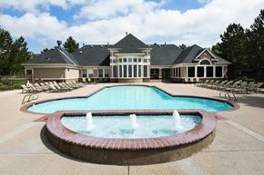 Denver apartment for rent - an apartment clubhouse behind a pool and fountain