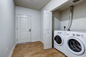 Seattle apartment for rent - A white door is in a room with a washer and dryer.