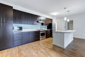 Seattle apartment for rent - A modern kitchen with dark wood cabinets and a white island.