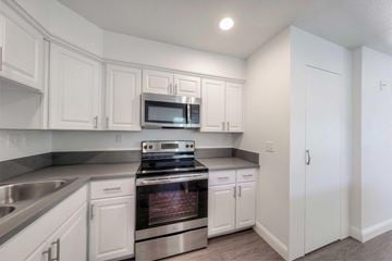 Fresno apartment for rent - A kitchen with white cabinets and a stainless steel oven.