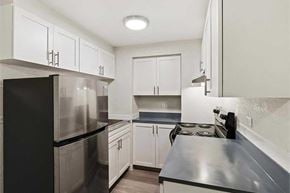Denver apartment for rent - A kitchen with black appliances and white cabinets.