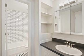 Denver apartment for rent - A white bathroom with a black counter top and a white sink.