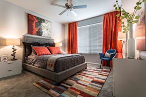 Phoenix apartment for rent - A bedroom with a bed, a chair, and a painting on the wall.