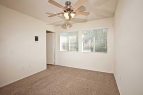 Oceanside apartment for rent - A room with a ceiling fan and carpeted floor.