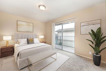 Turlock apartment for rent - A bedroom with a large bed and a balcony.