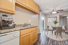 Modesto apartment for rent - A kitchen with wooden cabinets and a marble backsplash.