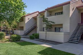 Coalinga apartment for rent - The exterior of the apartment building with grass areas and trees.