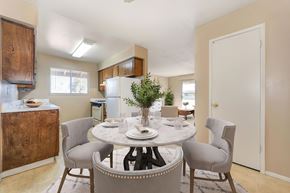 Modesto apartment for rent - A dining room with a table set and the kitchen in the near background.
