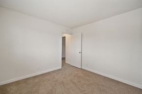 Oceanside apartment for rent - a bedroom with white walls and carpet.