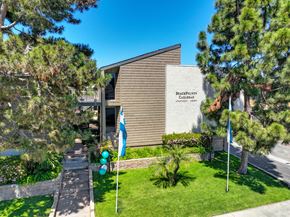 Carlsbad apartment for rent - a building with flags and trees in front of it