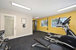 Escondido apartment for rent - A gym with a yellow wall, exercise bikes, and a weight machine.
