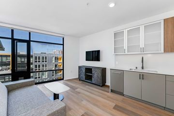 San Diego apartment for rent - A modern living room with a grey sofa and a flat screen TV.