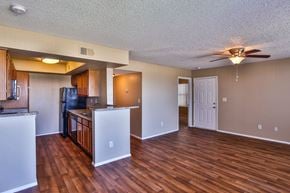 Henderson apartment for rent - Apartment interior kitchen and living room with ceiling fan and wood-style vinyl plank flooring.