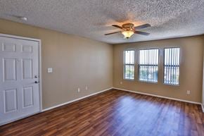 Henderson apartment for rent - Living room with ceiling fan, wood-style vinyl plank flooring, and windows with tons of natural light.