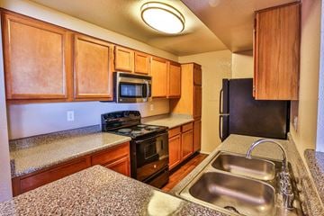 Henderson apartment for rent - A kitchen with wooden cabinets and a granite counter top.