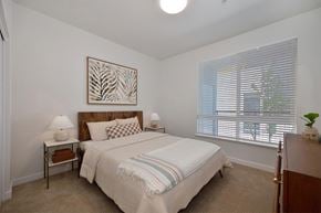 Reno apartment for rent - A bedroom with a large bed and a painting on the wall.