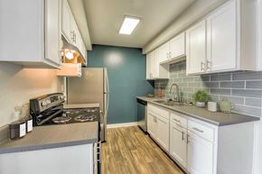 Santee apartment for rent - A kitchen with white cabinets and a grey countertop.