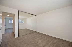 Carlsbad apartment for rent - an empty bedroom with mirrored closet doors and carpeting