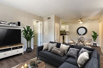 Pittsburg apartment for rent - A living room with a grey couch and a television on a wooden stand.