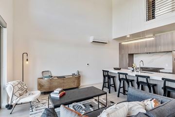Sacramento apartment for rent - A modern living room with a black coffee table and a white chair.