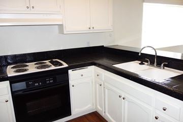 La Mesa apartment for rent - A black and white kitchen with a stove and sink.