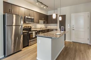 Phoenix apartment for rent - A modern kitchen with stainless steel appliances and wooden flooring.