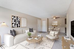 Colorado Springs apartment for rent - A living room with a white couch, a coffee table, and a television.