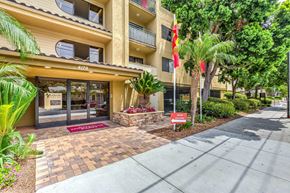 San Diego apartment for rent - A yellow exterior of a building with green trees