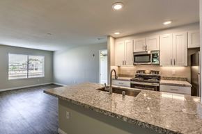 San Diego apartment for rent - A kitchen with granite countertops and kitchen appliances including a sink.