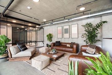 National City apartment for rent - A modern living room with a brown leather couch and a glass door.