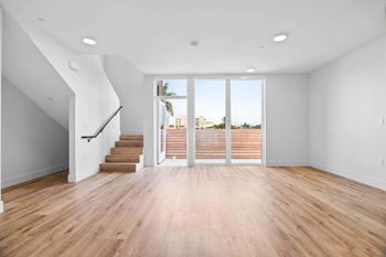 Units feature high ceilings, expansive windows, and wood-inspired floors
