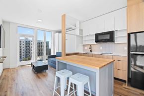National City apartment for rent - A kitchen with a wooden counter top and white stools.