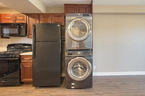 San Diego apartment for rent - A black refrigerator and a silver washing machine and dryer in a kitchen.